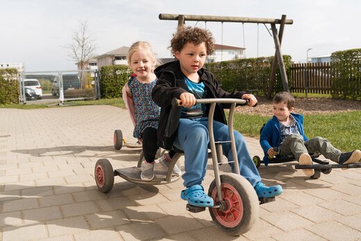 Kinder Spielen mit Dreirädern