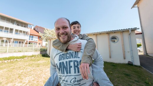 Erzieher trägt einen Jugendlichen Huckepack