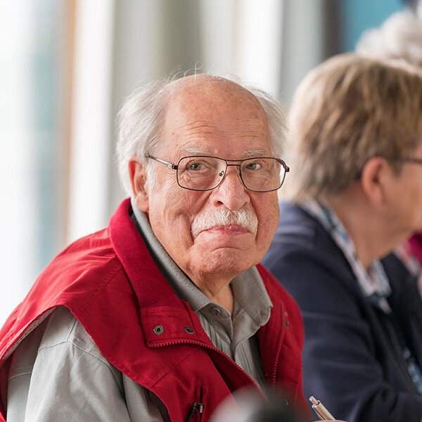 älterer Herr sitzt am Tisch