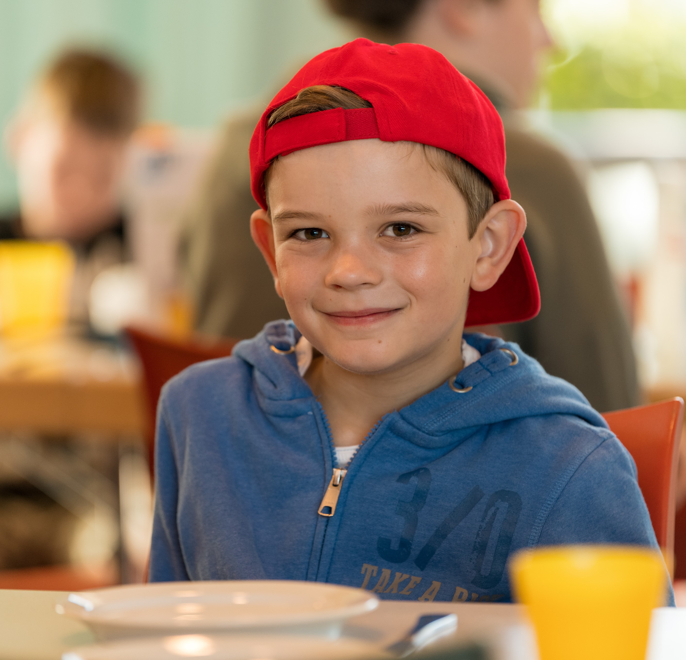 Junge mit roter Kappe am Esstisch