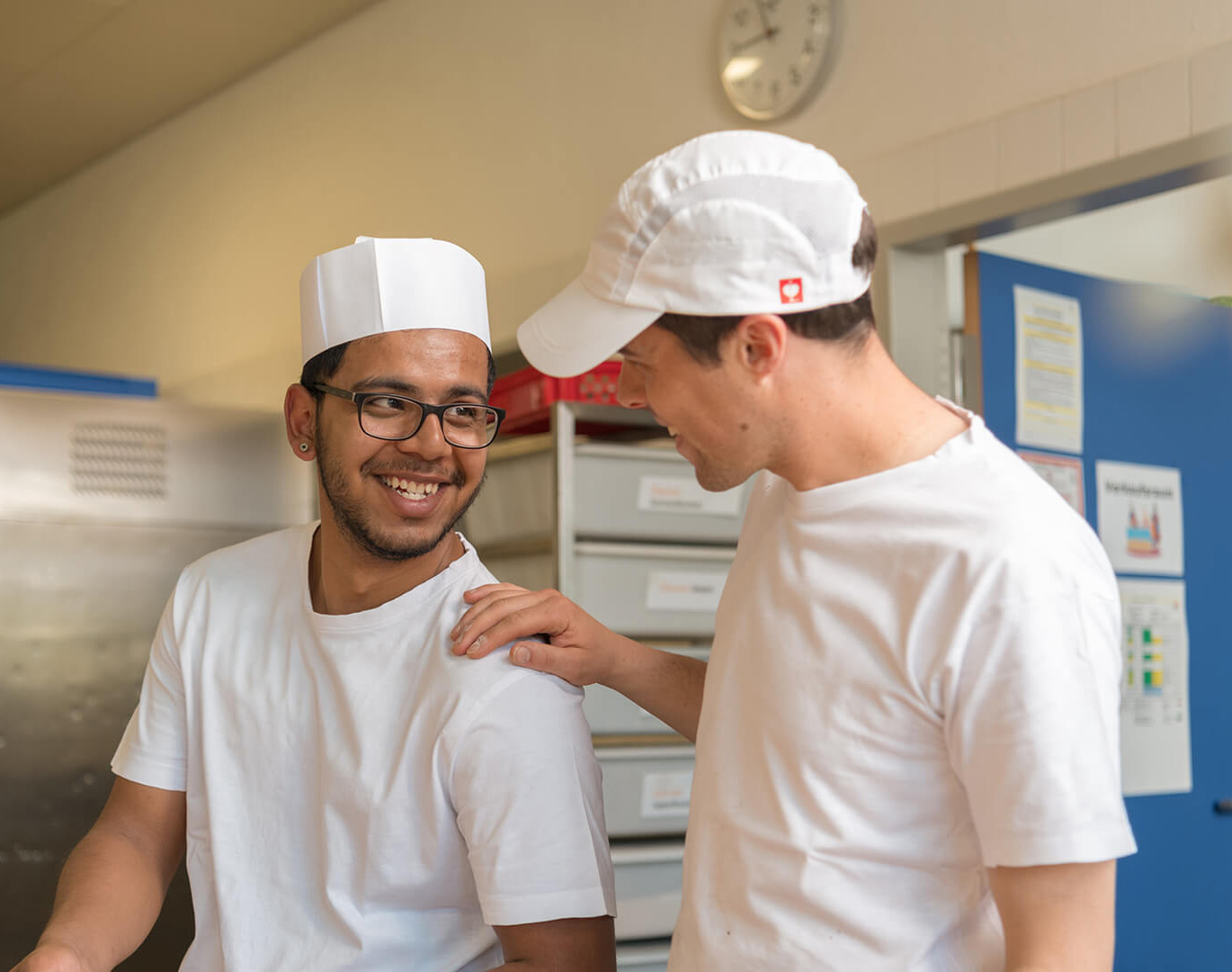 Bäcker und Bäckerei-Auszubildender im Gespräch