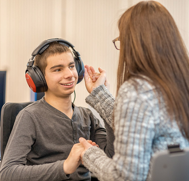 Junge mit Kopfhörer bekommt in der Audiologie das Gehör vermessen