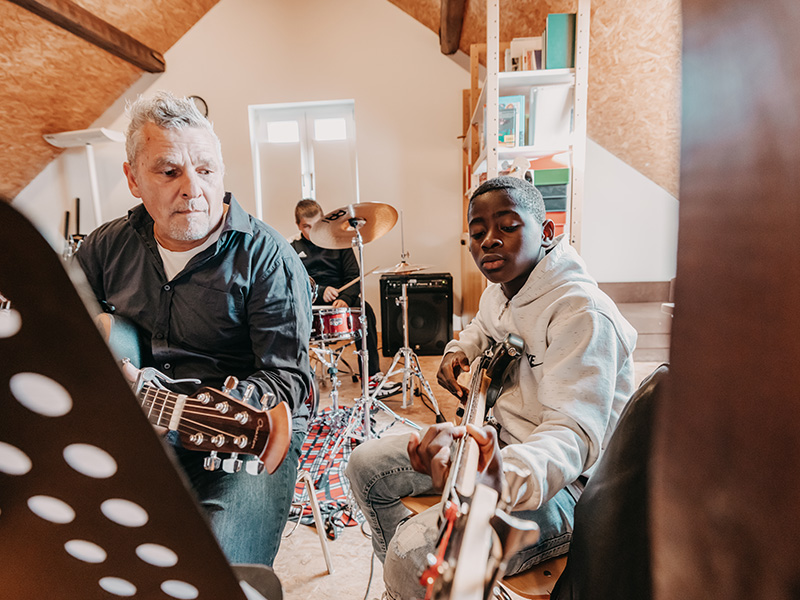 Band der Kinder- und Jugendhilfe im Proberaum an den Instrumenten